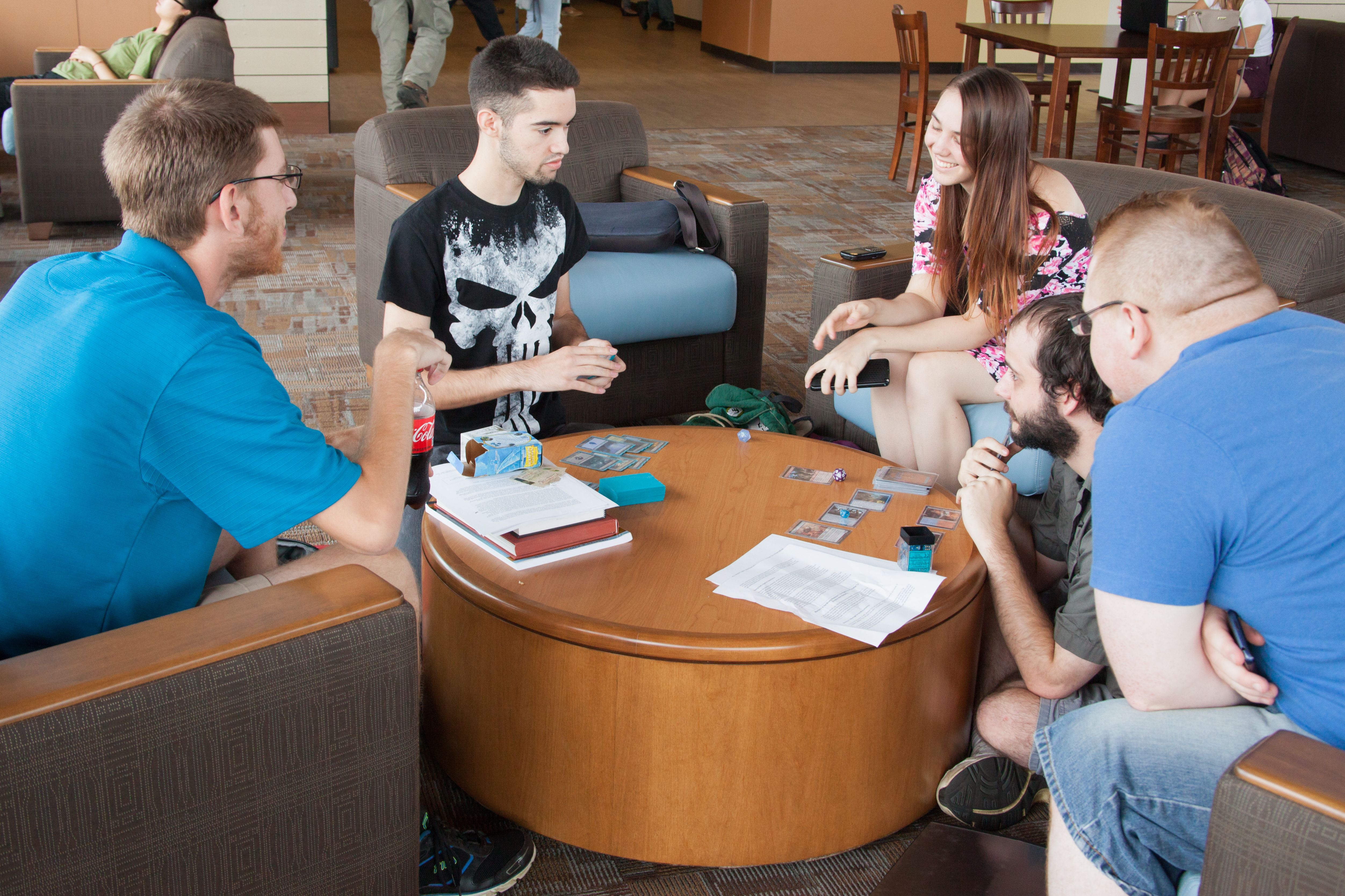 students play cards around table