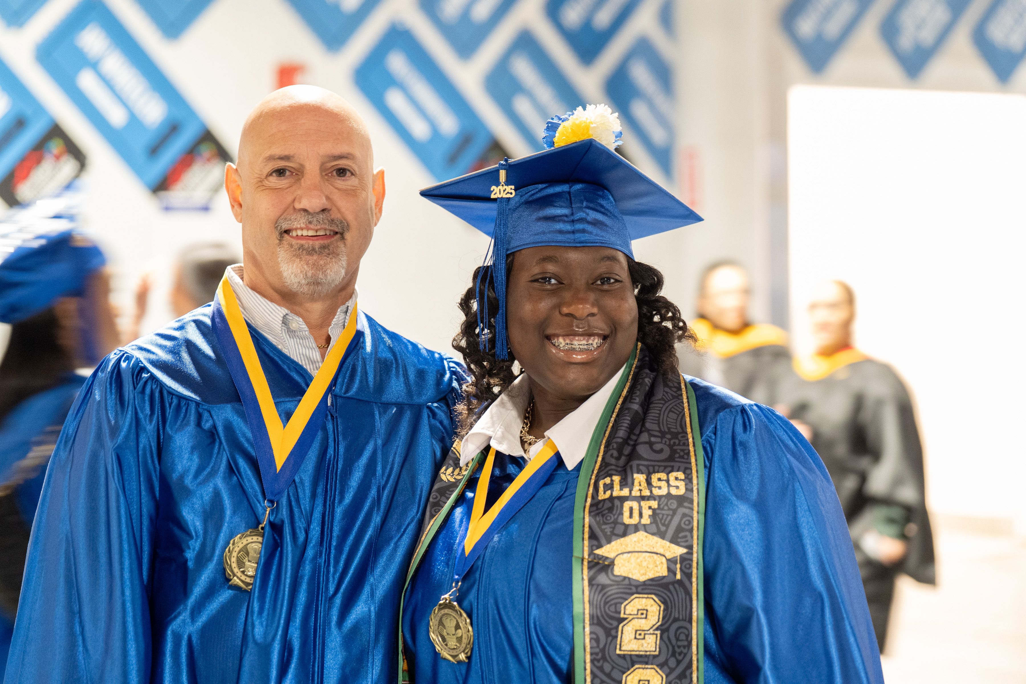 Two graduates smile at camera