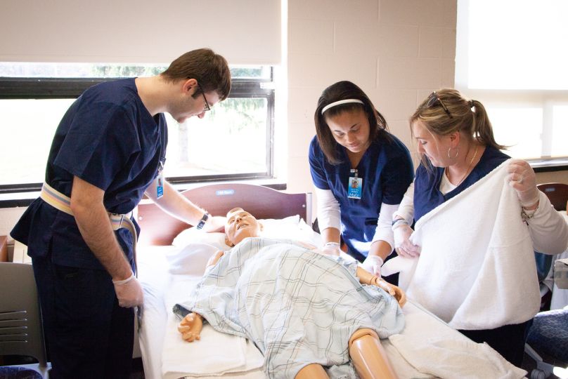 students in lab work together to cover patient.