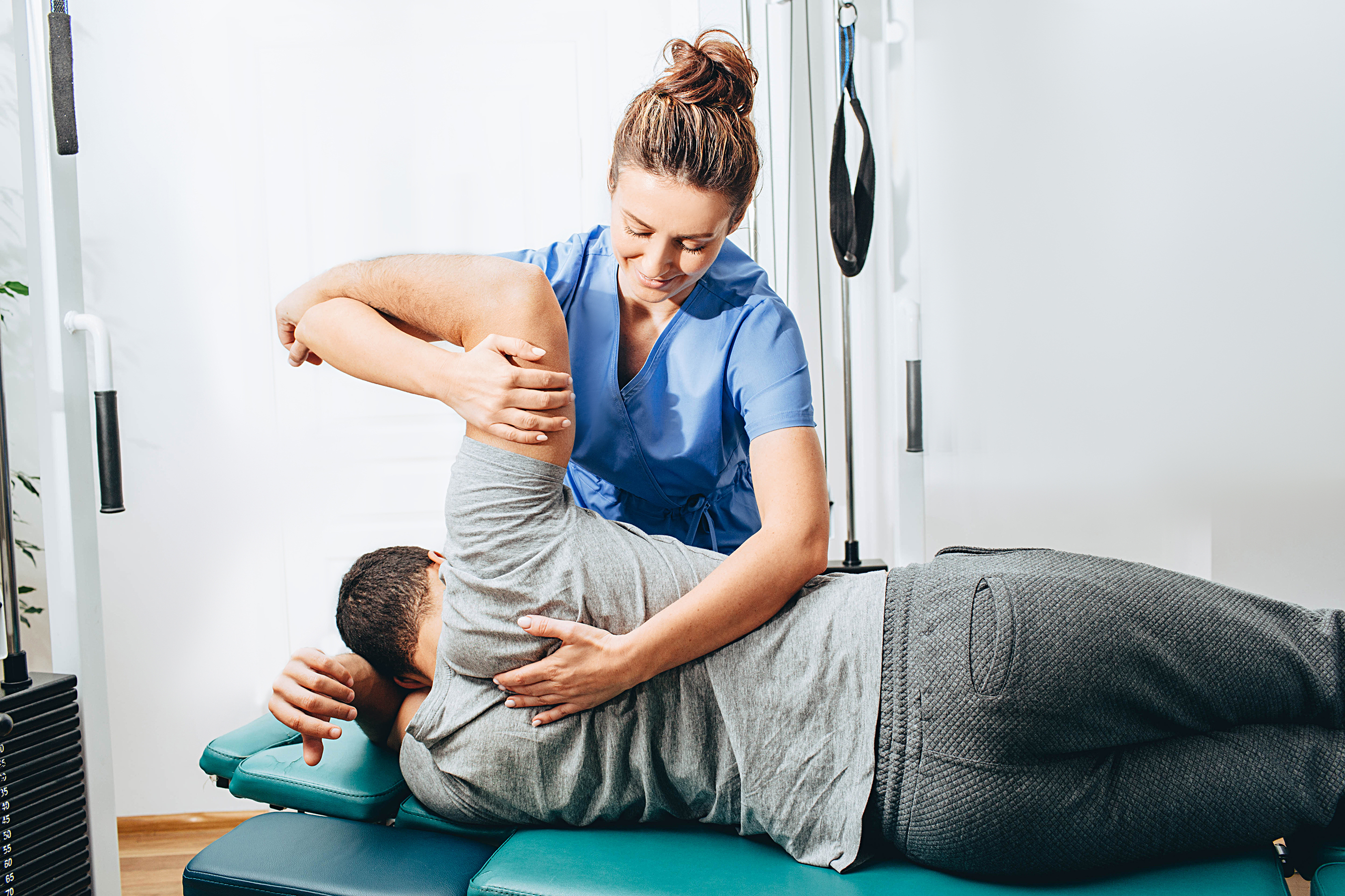 physical therapist works on patient's shoulder