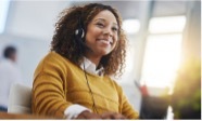 woman working in support center smiles with headset
